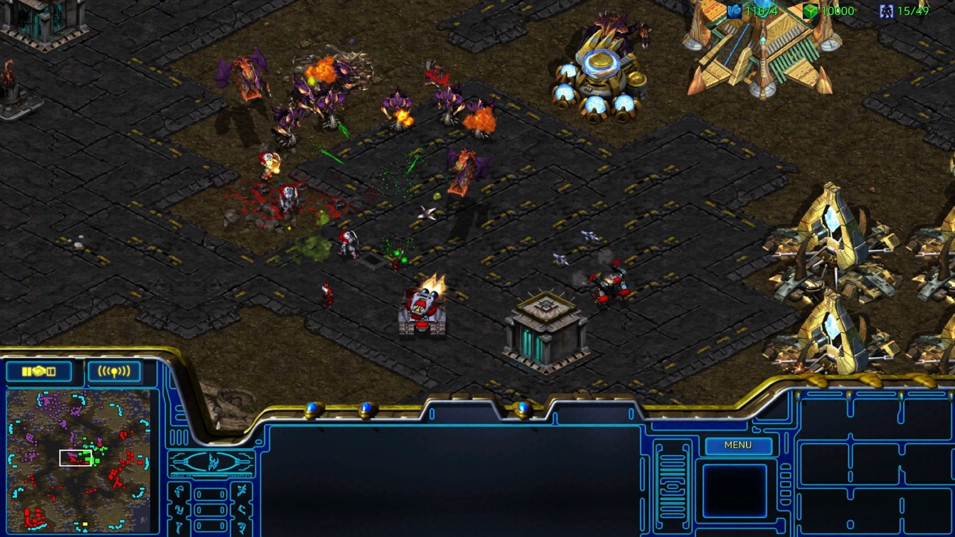 StarCraft Remastered gameplay showing Zerg units clashing with Protoss forces - asymmetric balance in action